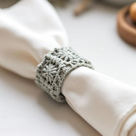 portatovagliolo grigio ad uncinetto con dentro un tovagliolo su una tavola