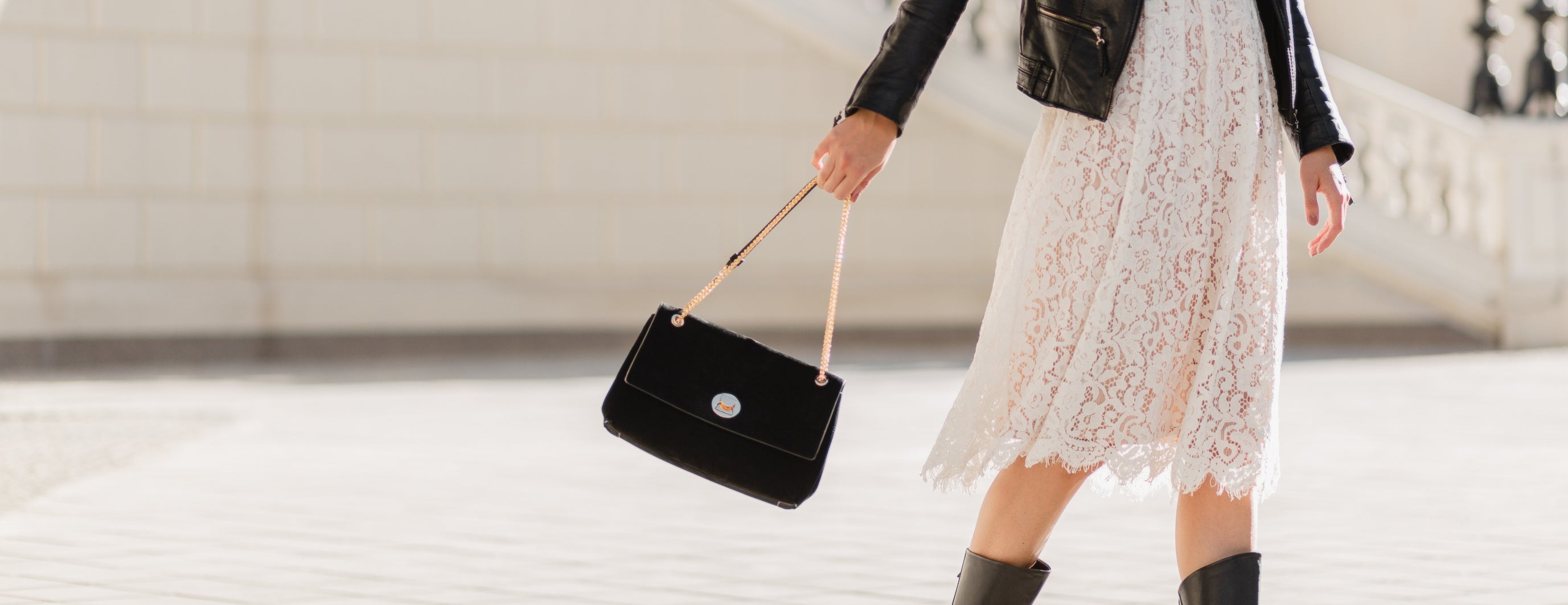 modella con borsa nera di pelle in mano in città